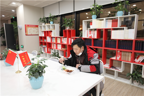 意外滯留在園區(qū)內(nèi)的快遞小哥收到了青年志愿者送來(lái)的一份熱騰騰晚餐，讓這個(gè)冬雪夜更暖心.jpg
